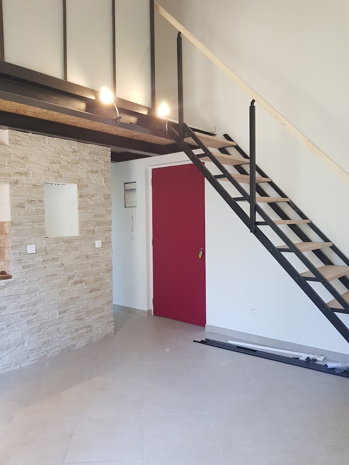 Escalier métallique et mur en pierres apparentes