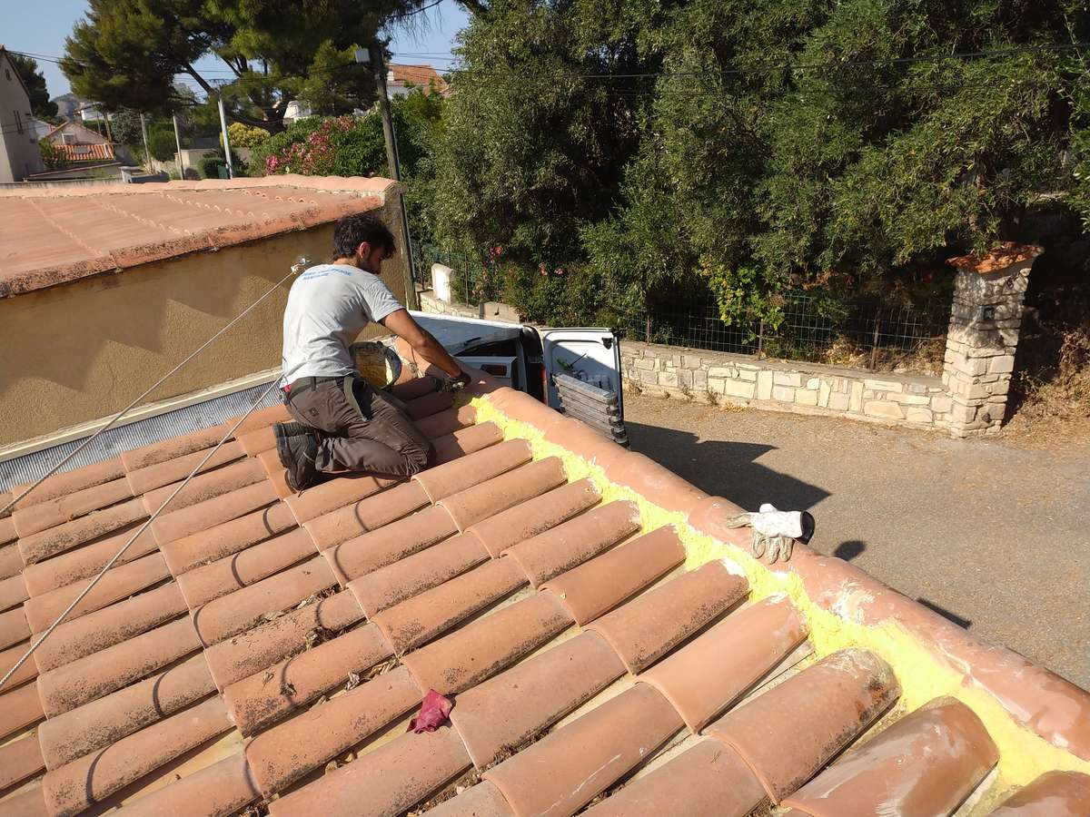 Couvreur au travail sur un toit en tuiles